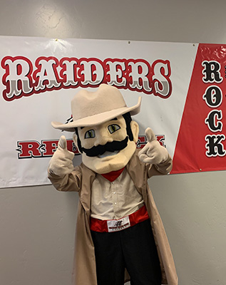 Raiders mascot in front of Raiders wall banner