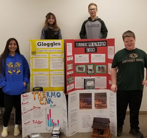 students next to science boards