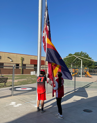Two students raising a flag